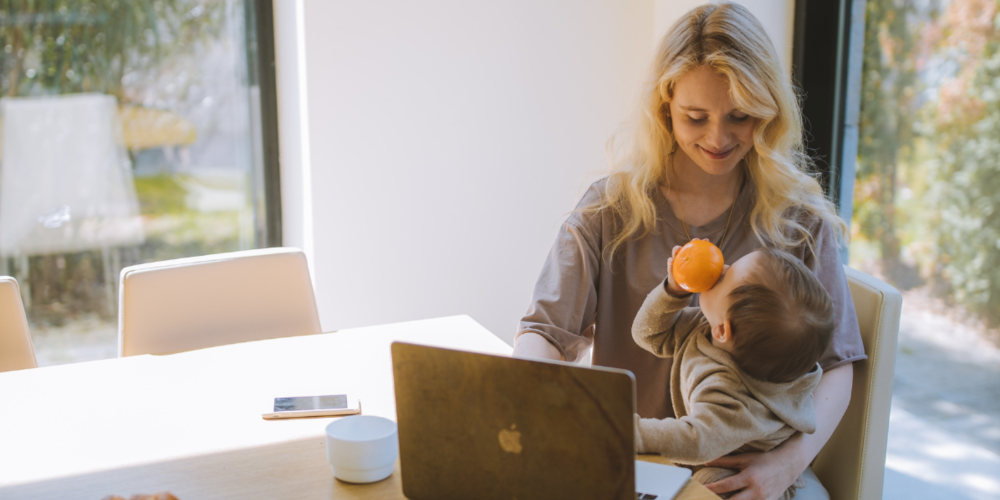 Foto van vrouw met kind achter een laptop