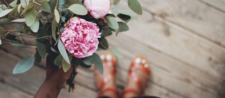 Foto roze pioenrozen sandalen houten vloer 