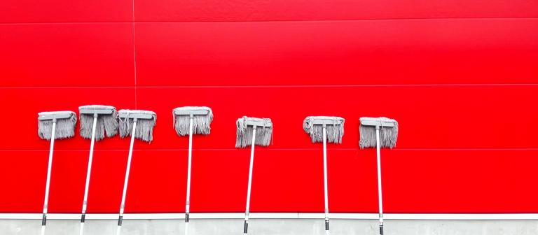 foto van dweilen tegen rode muur | Photo by pan xiaozhen on Unsplash