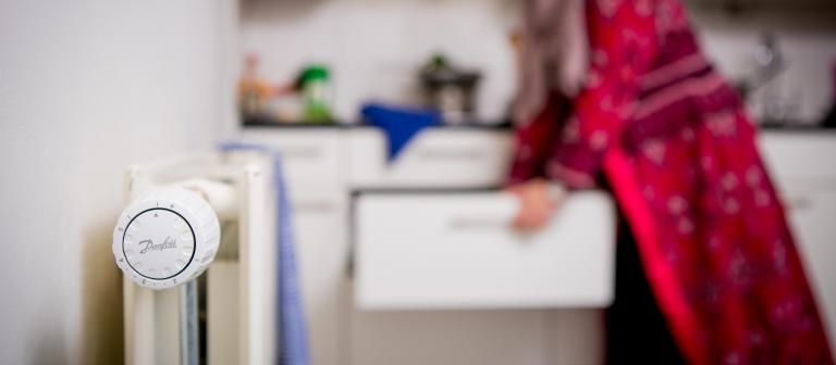 Foto van een radiator in een keuken en een vrouw