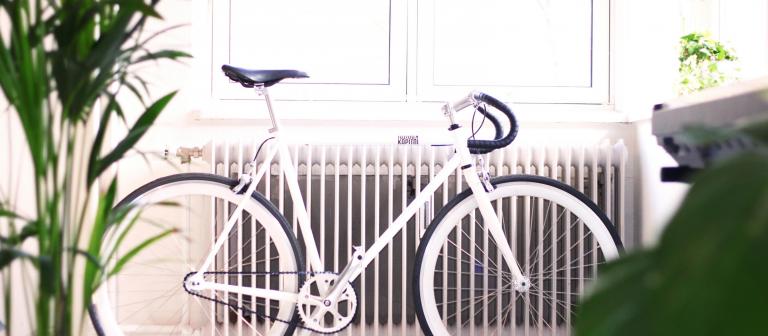 Foto van een witte fiets voor een radiator