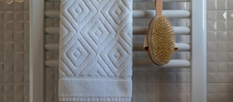 Foto van een handdoek en borstel op een badkamer radiator