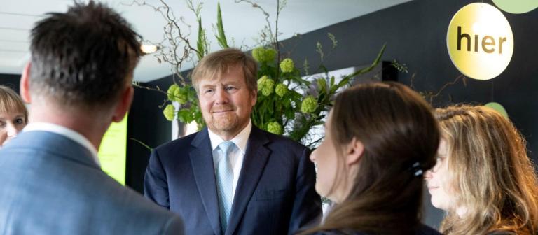 Foto van koning Willem-Alexander in gesprek met collega's van HIER