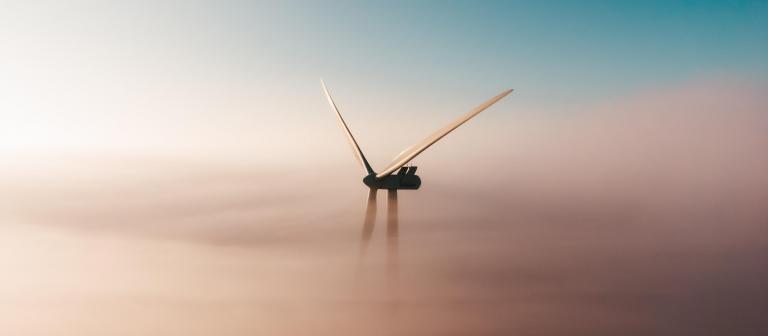 Foto van een windmolen in de mist