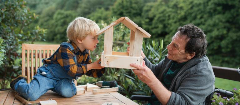 Opa en kleinkind bouwen een vogelhuisje