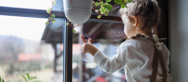 Kind kijkt naar buiten door het raam
