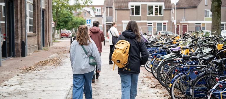 Mensen lopen bij fietsenstalling 