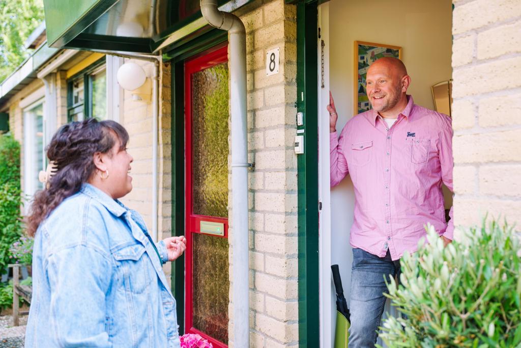 Foto van buren die bij elkaar aan de deur staan om te praten over energie besparen