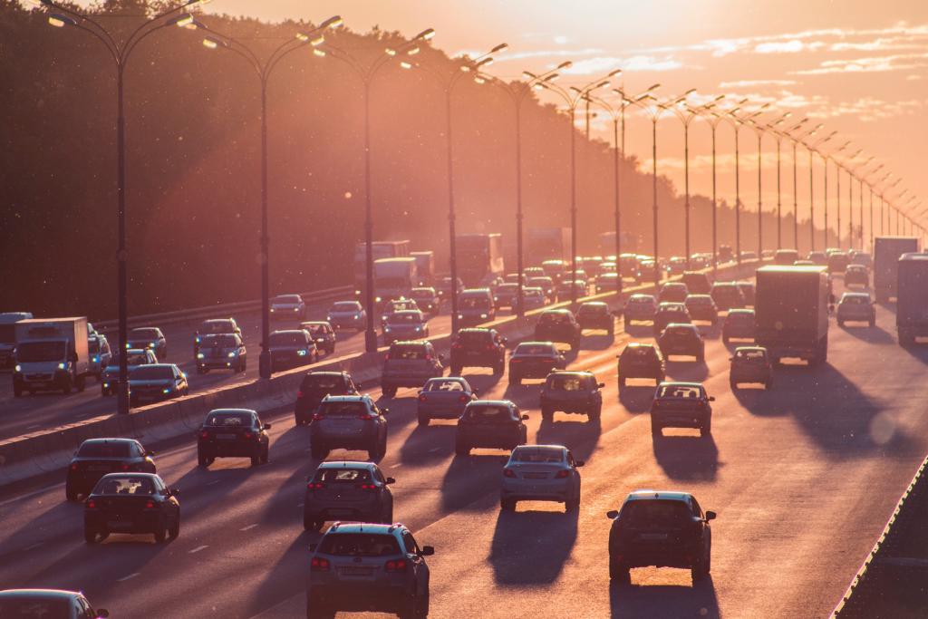 Foto van auto's op een snelweg bij zonsondergang