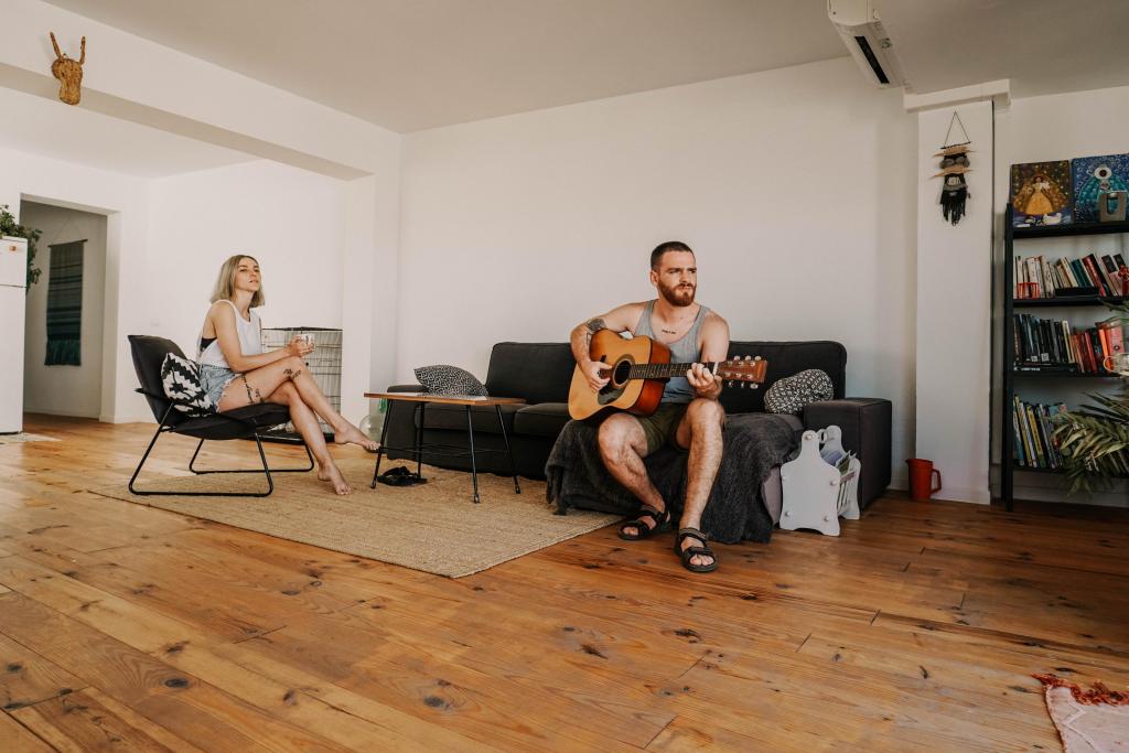 Foto van twee mensen in een woonkamer met een gitaar