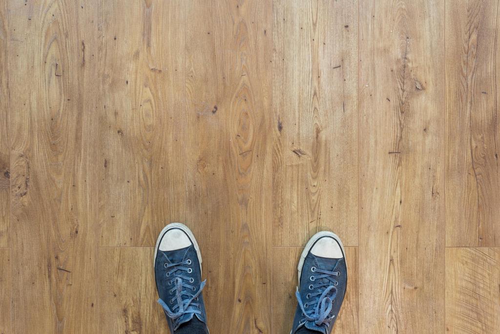 Bovenaanzicht van twee schoenen op een houten vloer
