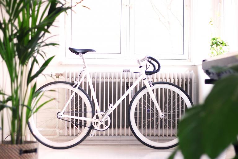 Foto van een witte fiets voor een radiator