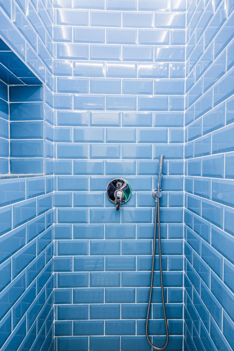 Foto van een blauw betegelde douche