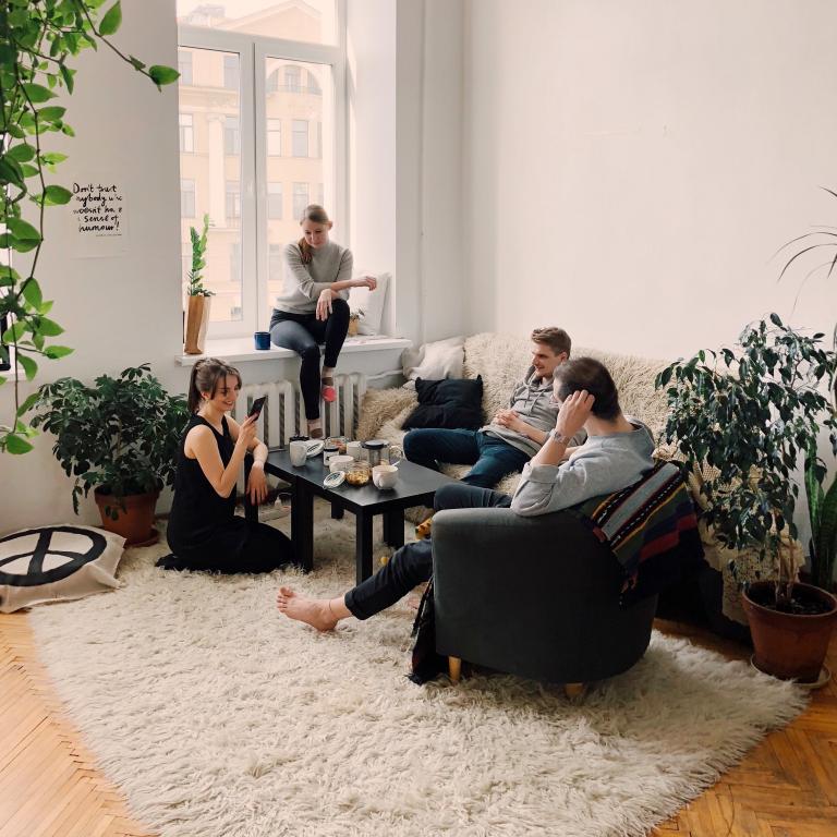 Foto van een groep mensen in een woonkamer 