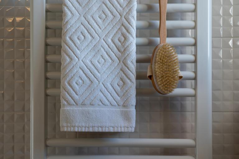 Foto van een handdoek en borstel op een badkamer radiator