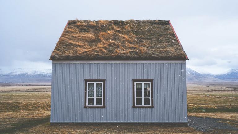 Foto van een huisje met een groen dak