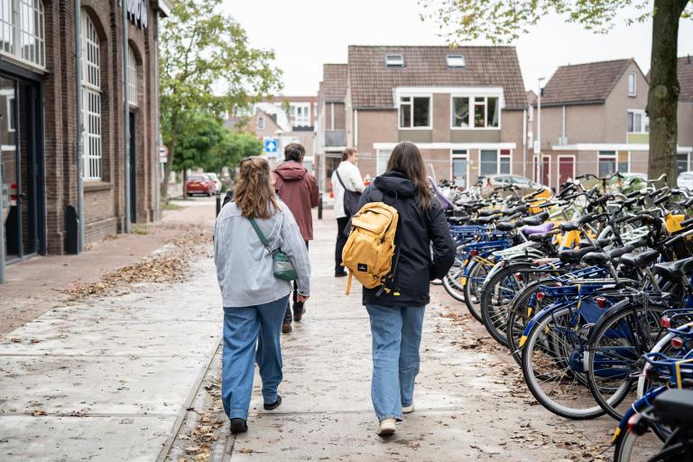 Mensen lopen bij fietsenstalling 