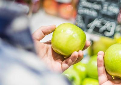 Foto van man die twee appels vergelijkt