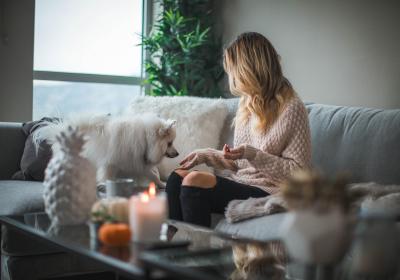 Foto van een vrouw op een bank met een hond schapenkleed kaarsen