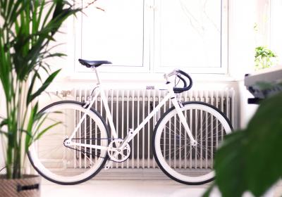 Foto van een witte fiets voor een radiator
