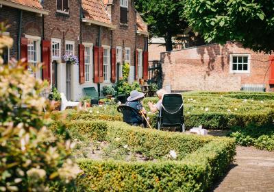 Foto van twee mensen die voor hun huis zitten
