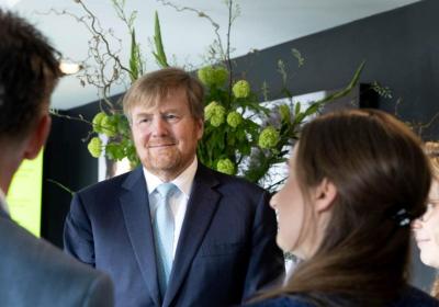 Foto van koning Willem-Alexander in gesprek met collega's van HIER