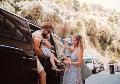 Foto van een familie bij een auto