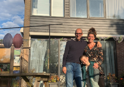 Patrick met zijn gezin voor hun huis 